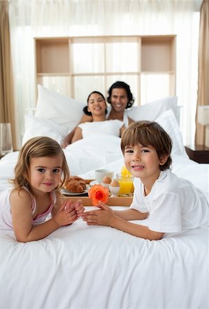Siblings having breakfast with their parents lying on the bed Stock Photo - Budget Royalty-Free & Subscription, Code: 400-04193367