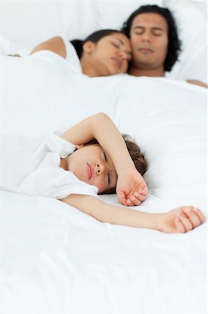 simsearch:400-04192370,k - Cute little boy sleeping with his parents in the background Fotografie stock - Microstock e Abbonamento, Codice: 400-04193378