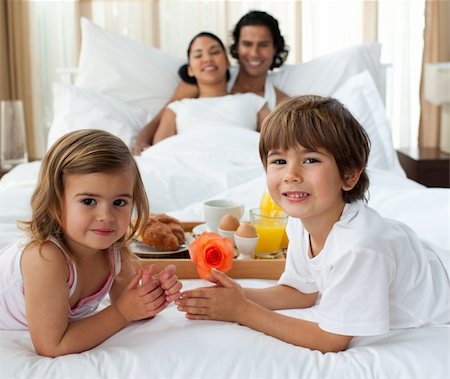 Portrait of a Smiling family having breakfast in the bedroom Foto de stock - Super Valor sin royalties y Suscripción, Código: 400-04193370