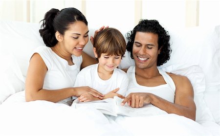 simsearch:400-04192370,k - Smiling little boy reading with his parents on the bed Fotografie stock - Microstock e Abbonamento, Codice: 400-04193385
