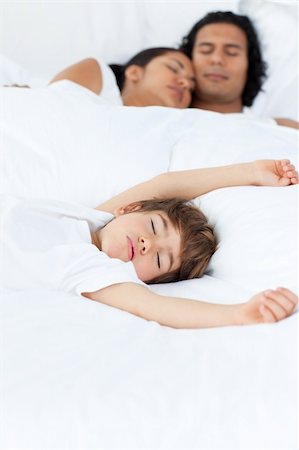 simsearch:400-04192370,k - Parents and their son sleeping on the bed in parent's bedroom Fotografie stock - Microstock e Abbonamento, Codice: 400-04193382