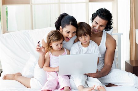 Family using a laptop on the sofa at home Stock Photo - Budget Royalty-Free & Subscription, Code: 400-04193396