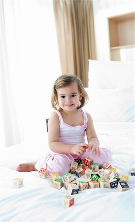 Cute little girl playing with alphabetics blocks on the bed Stock Photo - Budget Royalty-Free & Subscription, Code: 400-04193407