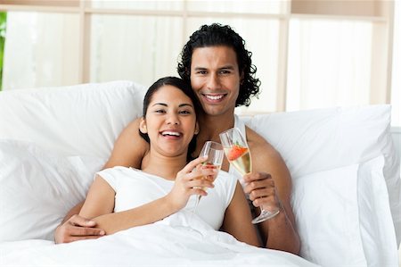 simsearch:400-04150404,k - Smiling lovers toasting with Champagne lying on the bed Stock Photo - Budget Royalty-Free & Subscription, Code: 400-04193400