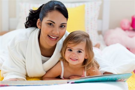 simsearch:400-05751566,k - Portrait of a smiling mother and her daughter reading together lying on the bed Stock Photo - Budget Royalty-Free & Subscription, Code: 400-04193419