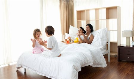 Parents having breakfast and children playing on the bed Stock Photo - Budget Royalty-Free & Subscription, Code: 400-04193412