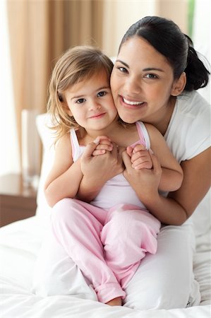 simsearch:400-04192370,k - Smiling mother hugging her little girl on the bed Stock Photo - Budget Royalty-Free & Subscription, Code: 400-04193434
