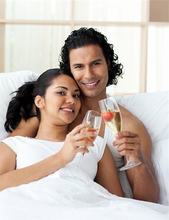 simsearch:400-04150404,k - Happy young couple toasting with Champagne lying on the bed Stock Photo - Budget Royalty-Free & Subscription, Code: 400-04193458