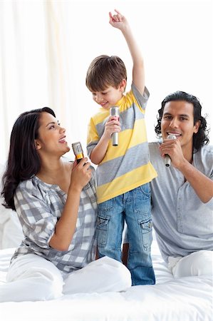 Adorable little boy singing with his parents on a bed Stock Photo - Budget Royalty-Free & Subscription, Code: 400-04193498