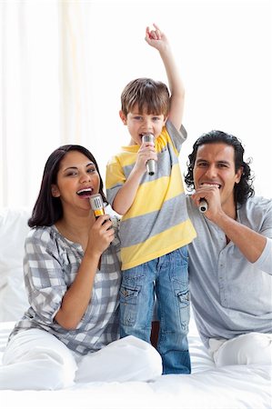 Animated family singing with microphones on a bed Stock Photo - Budget Royalty-Free & Subscription, Code: 400-04193499