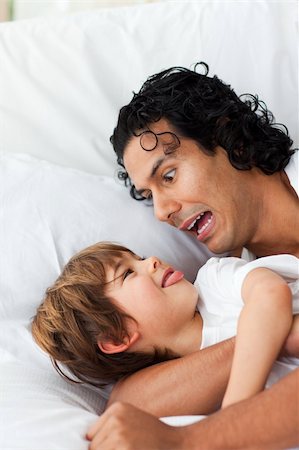 simsearch:400-04192370,k - Cheerful father having fun with his son lying on bed Stock Photo - Budget Royalty-Free & Subscription, Code: 400-04193493