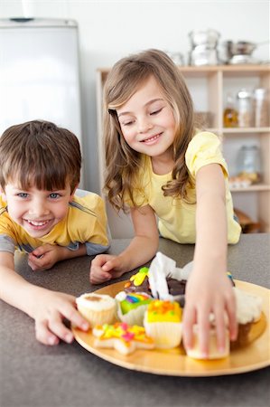 simsearch:695-05773760,k - Sister and brother eating cookies in the kitchen Photographie de stock - Aubaine LD & Abonnement, Code: 400-04193509