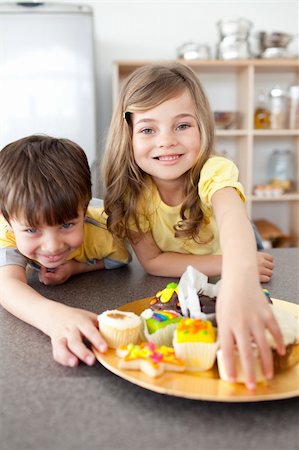 simsearch:695-05773760,k - Brother and sister eating cookies in the kitchen Photographie de stock - Aubaine LD & Abonnement, Code: 400-04193510