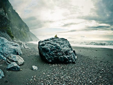stormy beach scene - Man sitting on a big rock on a rocky beach watching the ocean. Location: Hualien County, Taiwan Stock Photo - Budget Royalty-Free & Subscription, Code: 400-04193768