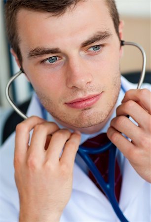 Portrait of an assertive male doctor holding a stethoscope against a white background Stock Photo - Budget Royalty-Free & Subscription, Code: 400-04204069