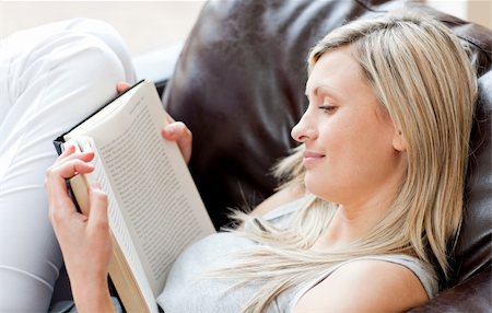 simsearch:400-04905604,k - Charming woman reading a book sitting on a sofa in a living-room Stockbilder - Microstock & Abonnement, Bildnummer: 400-04204113