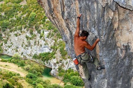 Rock climber moving up the rock, view with mountain river at the background Stock Photo - Budget Royalty-Free & Subscription, Code: 400-04204312