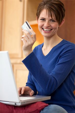 edbockstock (artist) - Attractive young woman holds up the credit card she is using to shop with on her laptop computer. Vertical shot. Photographie de stock - Aubaine LD & Abonnement, Code: 400-04204858