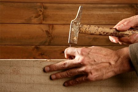simsearch:695-05778726,k - Carpenter hands with hammer wood and nail on wooden background Photographie de stock - Aubaine LD & Abonnement, Code: 400-04205057