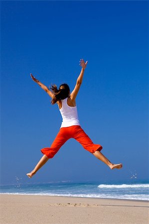 simsearch:400-06077546,k - Beautiful young woman jumping on  the beach Stockbilder - Microstock & Abonnement, Bildnummer: 400-04205207