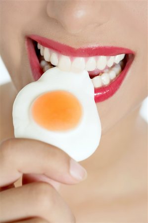 simsearch:400-04932642,k - Beautiful woman mouth with red lips eating a jelly egg Foto de stock - Super Valor sin royalties y Suscripción, Código: 400-04205460