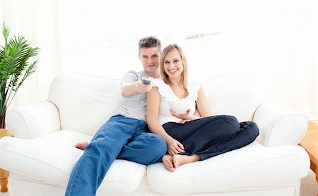 divert - Adorable couple using a remote in the living-room at home Stock Photo - Budget Royalty-Free & Subscription, Code: 400-04205516