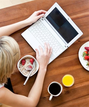 simsearch:400-04708507,k - Close-up of a caucasian woman using a laptop drinking coffee eating muesli Stock Photo - Budget Royalty-Free & Subscription, Code: 400-04205567