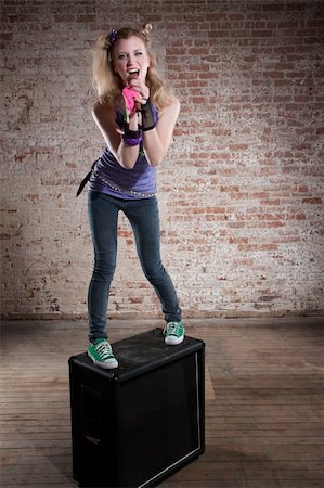 simsearch:400-04197216,k - Young punk rocker on a speaker in front of a brick background Photographie de stock - Aubaine LD & Abonnement, Code: 400-04206006