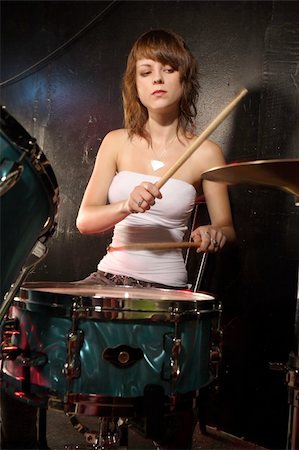 Photograph of a female drummer playing a drum set on stage. Stock Photo - Budget Royalty-Free & Subscription, Code: 400-04206417