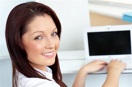 simsearch:400-04341796,k - Charming businesswoman using her laptop smiling at the camera in her office Stockbilder - Microstock & Abonnement, Bildnummer: 400-04206902