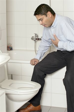 Photo of an adult male in his late thirties with stomach sickness about to vomit into his toilet. Stock Photo - Budget Royalty-Free & Subscription, Code: 400-04206992