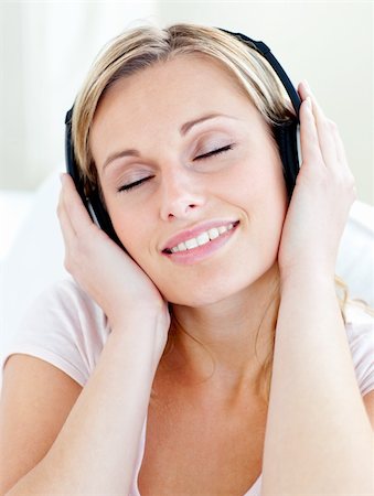 simsearch:400-04207132,k - Radiant young woman listen to music wearing headphones in the living room Foto de stock - Super Valor sin royalties y Suscripción, Código: 400-04207132