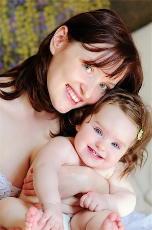 simsearch:400-06172843,k - Beautiful mother hugs her 9-months baby-daughter close-up Stock Photo - Budget Royalty-Free & Subscription, Code: 400-04207264
