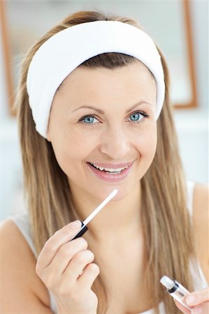 Delighted woman applying gloss on her lips in the bathroom Stock Photo - Budget Royalty-Free & Subscription, Code: 400-04208029