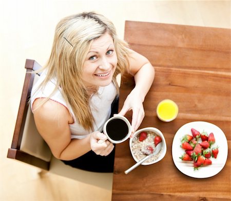 simsearch:400-05741872,k - Close-up of a woman using a laptop holding a cup of coffee eating muesli Stockbilder - Microstock & Abonnement, Bildnummer: 400-04208035