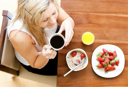 simsearch:400-04708507,k - Close-up of a blond woman using a laptop holding a cup of coffee eating muesli Stock Photo - Budget Royalty-Free & Subscription, Code: 400-04208036