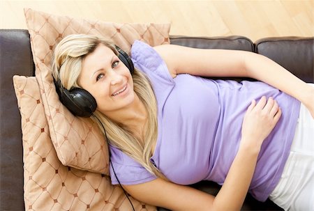 simsearch:400-04905827,k - Joyful woman listen to music wearing headphones sitting on a sofa Stock Photo - Budget Royalty-Free & Subscription, Code: 400-04208046