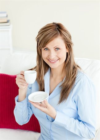 simsearch:400-04188263,k - Glowing businesswoman holding a cup sitting on a sofa at home Foto de stock - Super Valor sin royalties y Suscripción, Código: 400-04208063