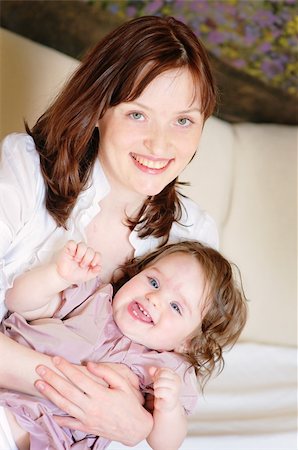 simsearch:400-06172843,k - Beautiful mother hugs her 9-months baby-daughter and smiling closeup Stock Photo - Budget Royalty-Free & Subscription, Code: 400-04208882