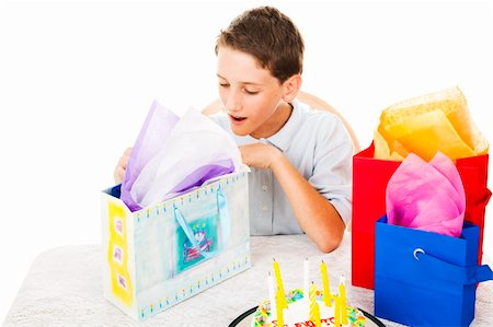 papier de soie - Cute little boy opening his birthday presents.  White background. Photographie de stock - Aubaine LD & Abonnement, Code: 400-04208990