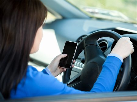 simsearch:400-04843851,k - Brunette young woman using her cellphone while driving in her car Stockbilder - Microstock & Abonnement, Bildnummer: 400-04209310