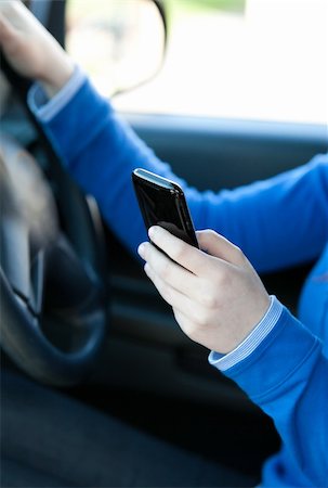 Close-up of a caucasian young woman sending a text while driving in her car Stock Photo - Budget Royalty-Free & Subscription, Code: 400-04209312