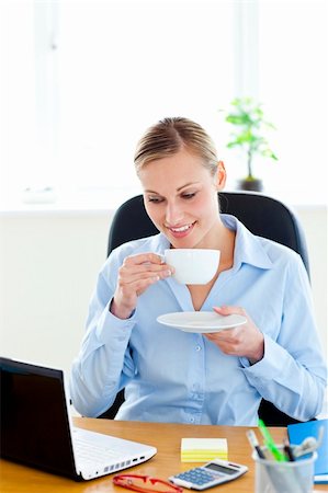 simsearch:400-04386602,k - Glad young businesswoman drinking coffee looking at her laptop in the office Stockbilder - Microstock & Abonnement, Bildnummer: 400-04209356