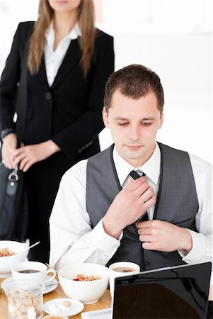 simsearch:400-04209411,k - Charming businesswoman standing in the background while her husband working at the laptop at home Fotografie stock - Microstock e Abbonamento, Codice: 400-04209390