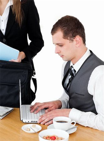 simsearch:400-04209411,k - Charming businesswoman standing near the table while her husband working at the laptop at home Fotografie stock - Microstock e Abbonamento, Codice: 400-04209391