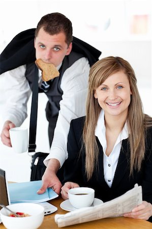 simsearch:400-04209411,k - Charming businesswoman reading the newspaper while her husband eating at home Fotografie stock - Microstock e Abbonamento, Codice: 400-04209393