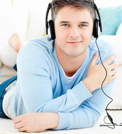 simsearch:400-04207132,k - Lively young man listen to music with headphones in the living room Foto de stock - Super Valor sin royalties y Suscripción, Código: 400-04209882