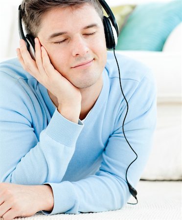 simsearch:400-04207132,k - Relaxed young man listen to music with headphones lying on the floor in the living-room Foto de stock - Super Valor sin royalties y Suscripción, Código: 400-04209883