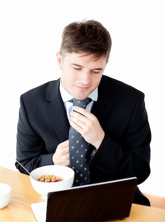 simsearch:400-04708507,k - Attractive young businessman making his tie looking at his laptop at the breakfast table Stock Photo - Budget Royalty-Free & Subscription, Code: 400-04209951