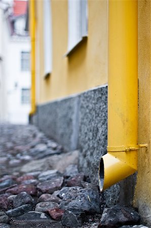 yellow downtake tube in street of old town in Tallinn, Estonia (extremely shallow depth of field, focus on front tube) Fotografie stock - Microstock e Abbonamento, Codice: 400-04200250